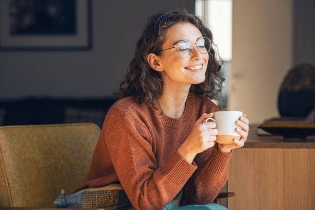 A woman is savoring her coffee