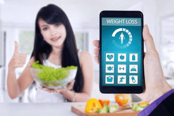 Intermittent fasting results 1 month after healthy eating, shown with weight loss app and salad bowl