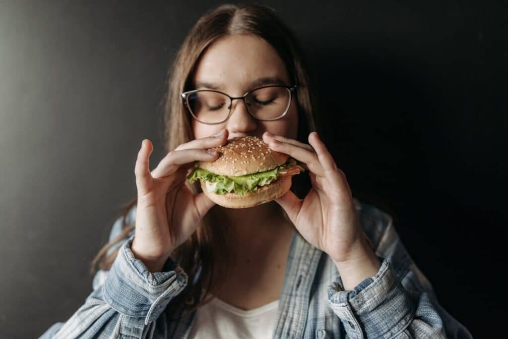 A women having a burger during intermittent fasting